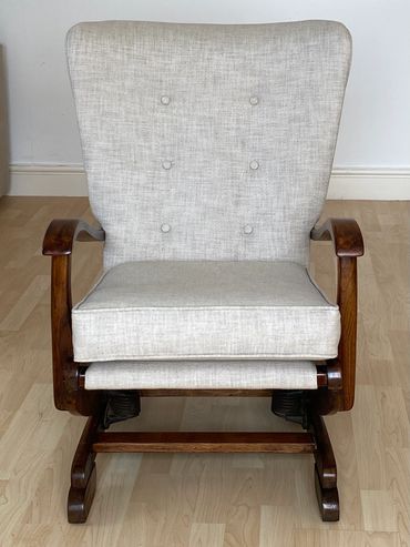Vintage wooden rocking chair with light beige cushioned upholstery.