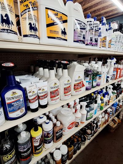 A store aisle filled with horse grooming and care products on shelves.