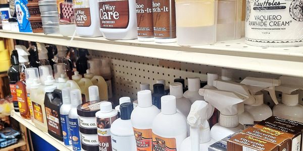 Shelf stocked with various shoe care products and conditioners.
