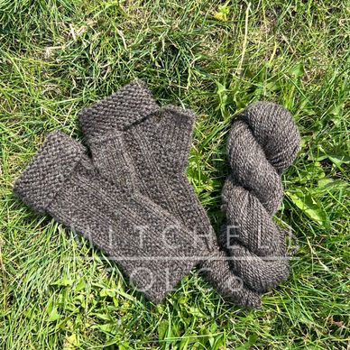 brown lambing mitts sit on green grass