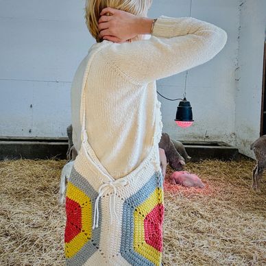 sherry models a crochet bag in white/ yellow red & blue