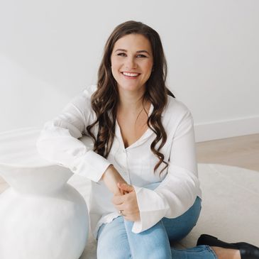 Smiling woman sitting casually indoors.