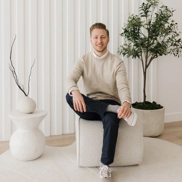 Man sitting on a textured cube in a stylish room.