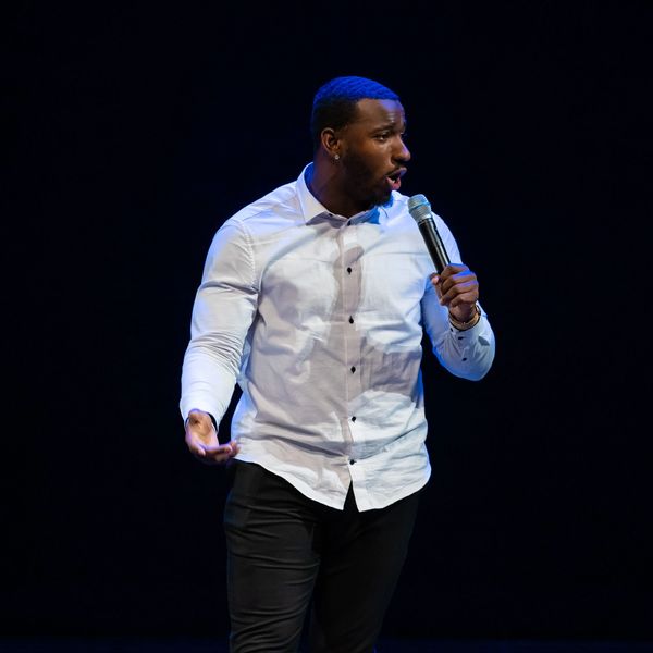 Man speaking passionately with a microphone on stage.