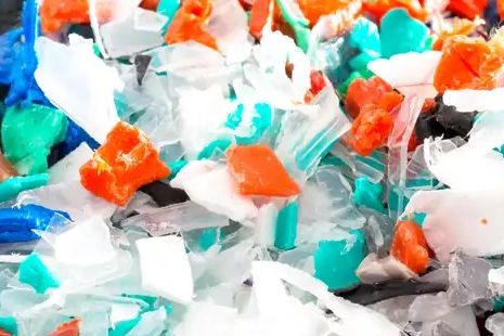Close-up of colorful plastic fragments in blue, white, orange, and green hues.