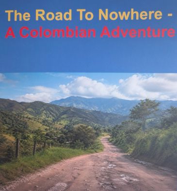 Dirt road leading through Colombian countryside with mountains in the background.