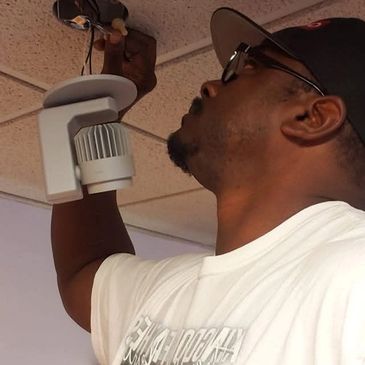 Man installing or fixing a ceiling light fixture.