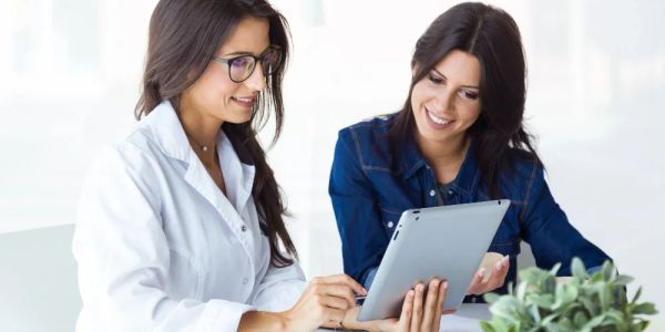 Doctor consulting a patient using a tablet.