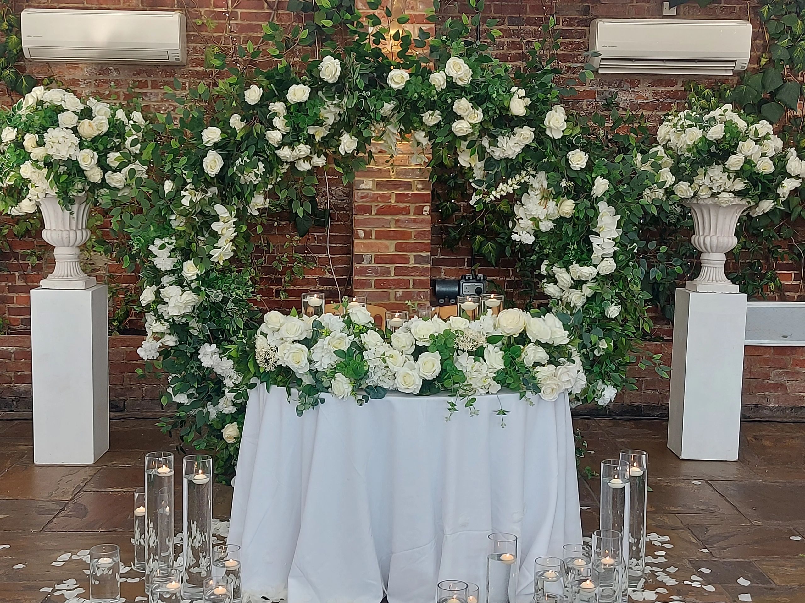 Elegant floral wedding decoration with white roses and candles.