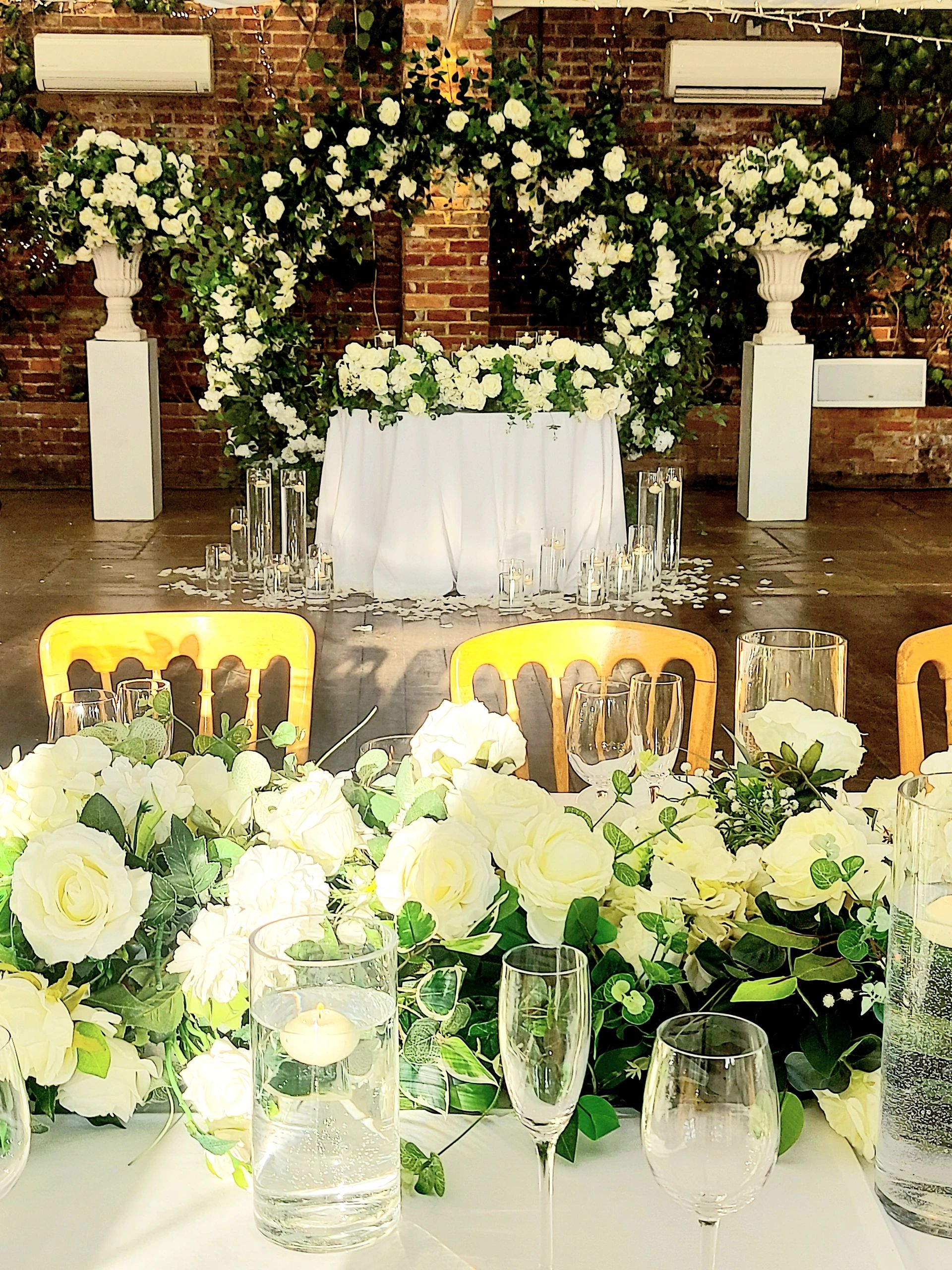 Elegant wedding floral arrangement with white roses and candles.