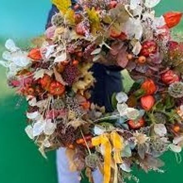 A colorful autumn wreath made of dried flowers and leaves.