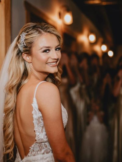 Bride smiling with elegant hairstyle and dress.