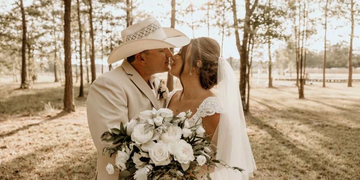 Bride and groom sharing a kiss at an outdoor wedding.