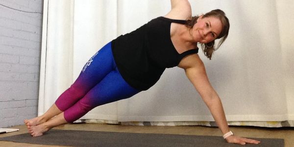 Yoga teacher, Roxanna Hunter, in side plank (Vasisthasana) during a Vinyasa Yoga class.