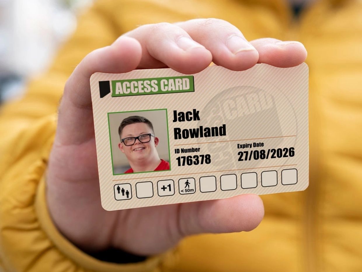 A hand holds up an Access Card.