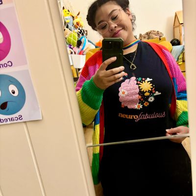 Clinical supervisor smiling and being inviting showing neuroaffirming shirt. She offers supervision.