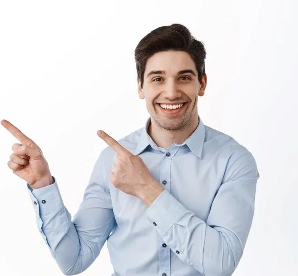 Smiling man in blue shirt pointing to his left.