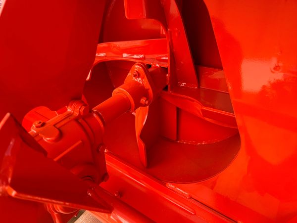 Close-up of a bright red mechanical component with shiny metal parts.