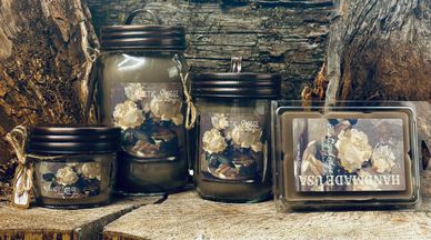Decorative jars and soap with dried flowers on a rustic wooden surface.