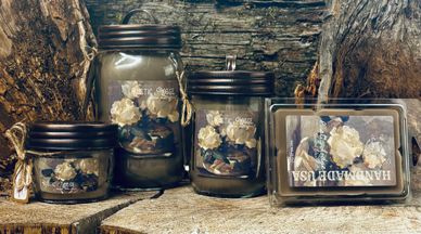 Decorative jars and soap with dried flowers on a rustic wooden surface.