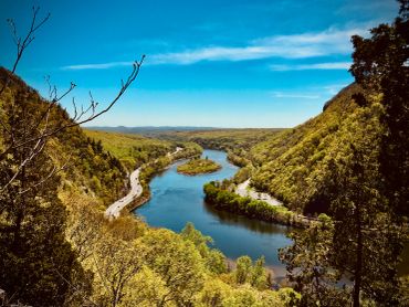 River winding through green hills under a clear blue sky.