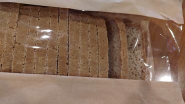 Sliced whole wheat bread in a partially opened transparent bag.