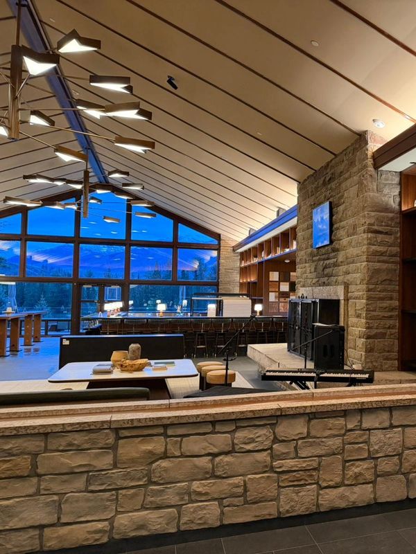 Cozy modern living room with stone fireplace and large windows.