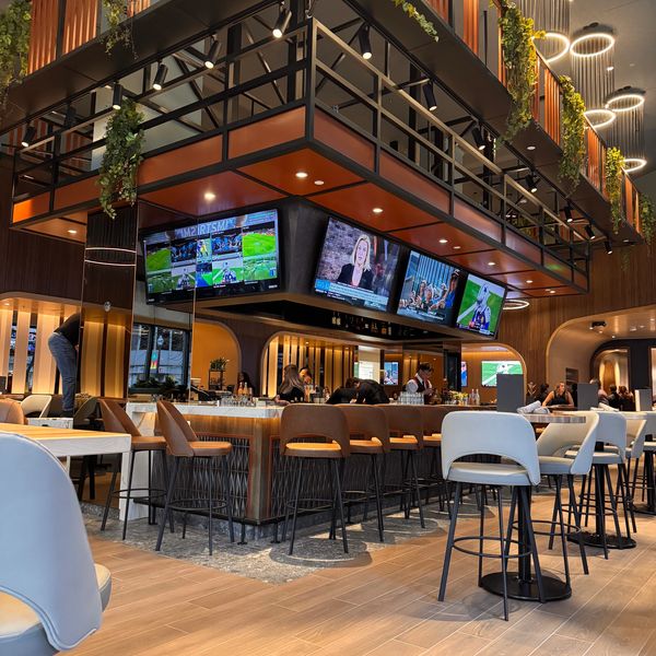 Modern bar with four TVs and stylish seating.