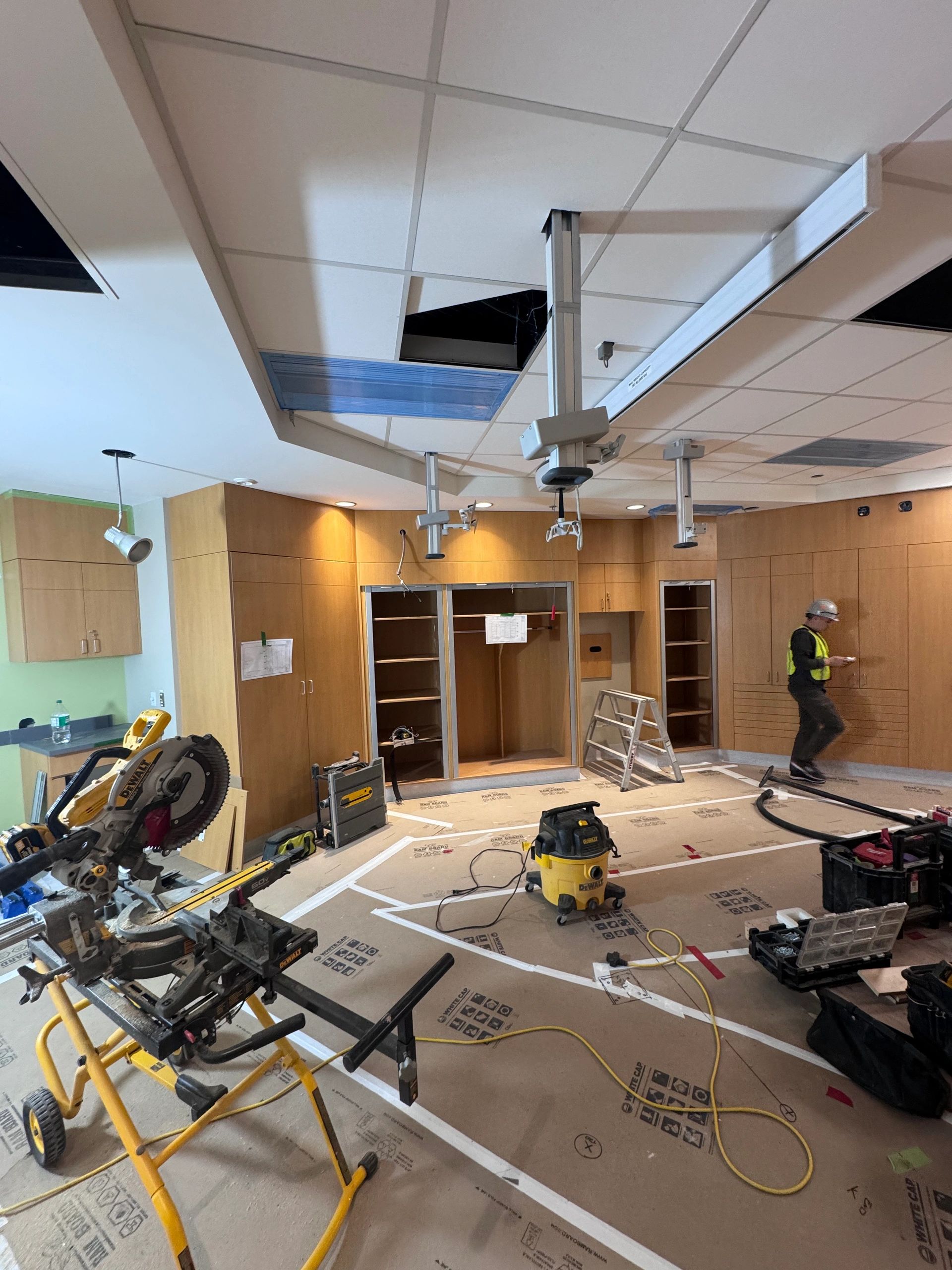 Custom millwork installation with cabinetry and open shelves in healthcare facility in progress