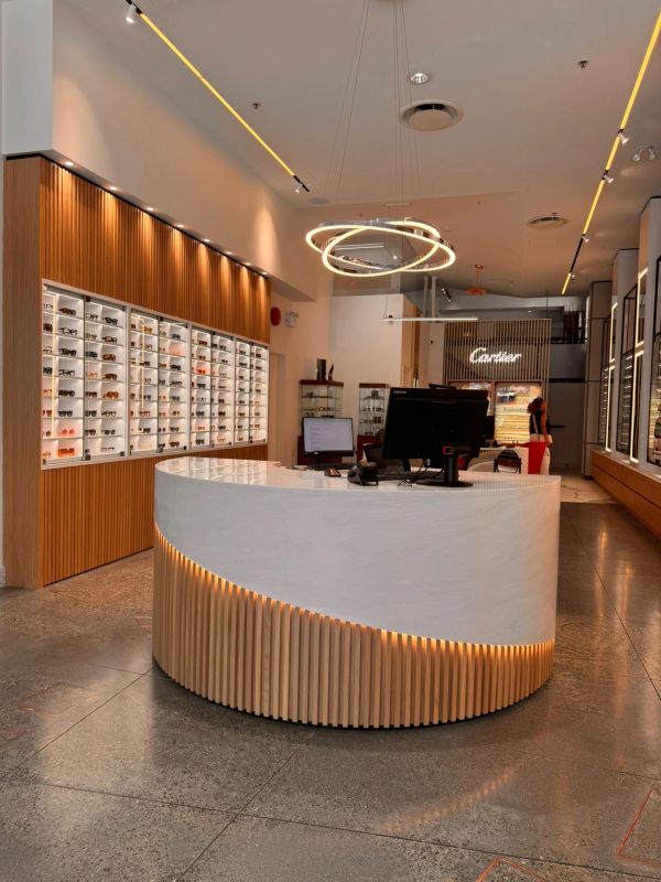 Modern optical store interior with sleek white and wood design.
