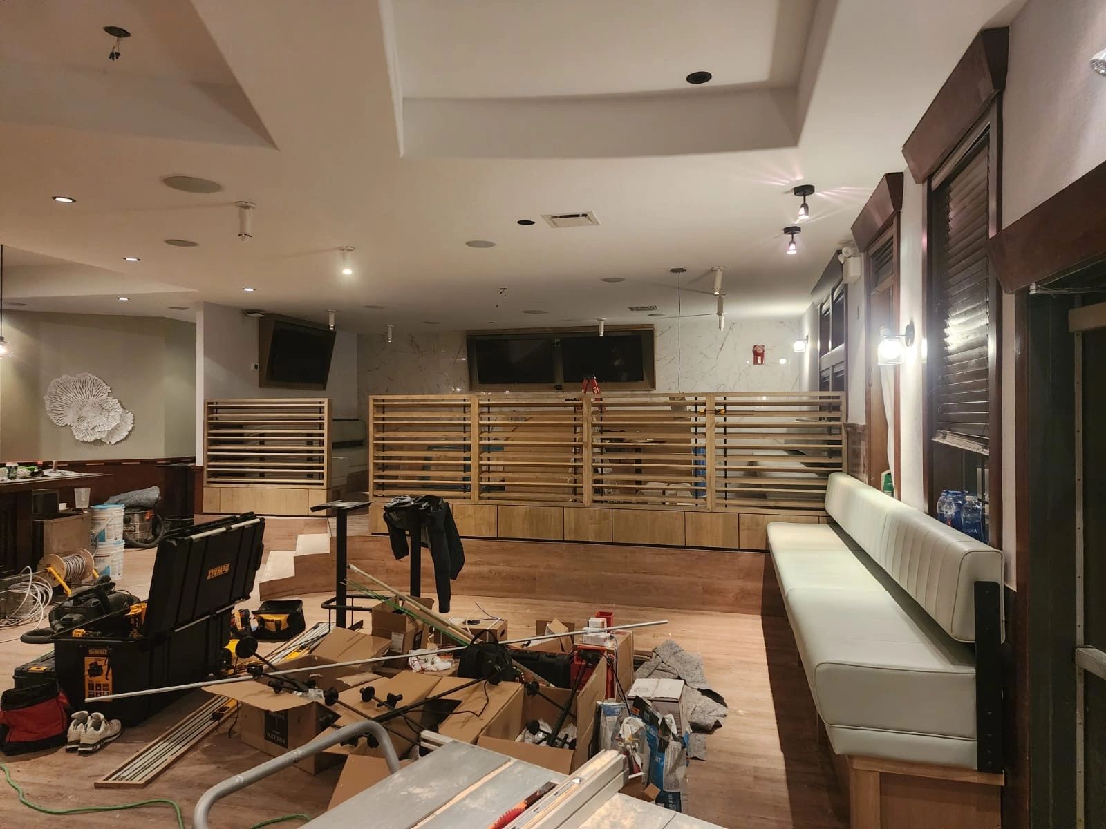 Restaurant interior in process with ongoing millwork installation and custom seating assembly
