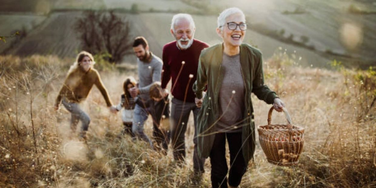 Happy family hiking outdoors with a picnic basket.