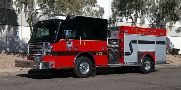 Red and black fire truck from Northern Arizona Fire District parked on street.