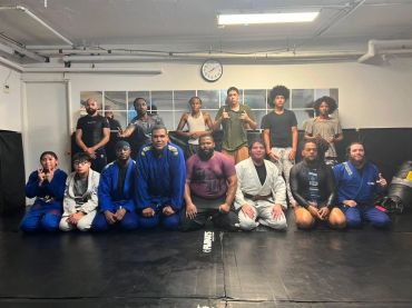 Group photo of martial arts practitioners on a mat.