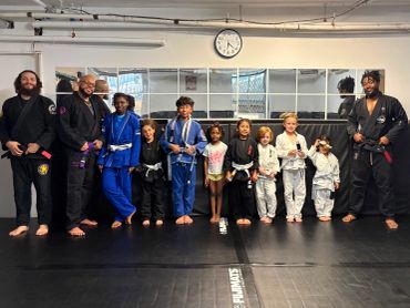 Group of people in martial arts uniforms standing in a dojo.