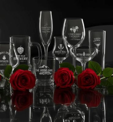 Variety of branded glassware with red roses on black surface.