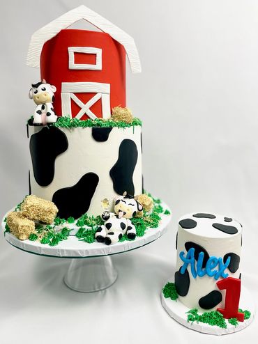 Holy Cow 1st Birthday Cake. Cows, and hay bails on a two-tier birthday cake with a barn on top. 