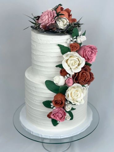 White Wedding Cake with Palette Knife Design. Cake Contains Handmade Edible Gumpaste Flowers. 