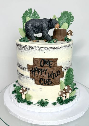 One Wild Cub Birthday Cake. Naked icing designs with forest inspired decorations including leaves.