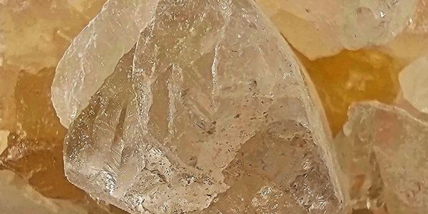 Close-up of translucent, irregularly shaped crystals with a brownish background.