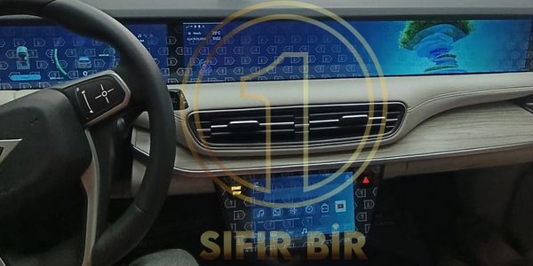 Modern car dashboard with digital displays and wood trim.