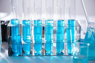 Test tubes filled with blue liquid in a lab rack.