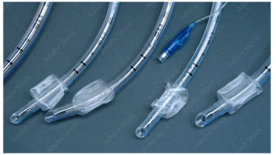 Various medical endotracheal tubes with connectors on a blue surface.