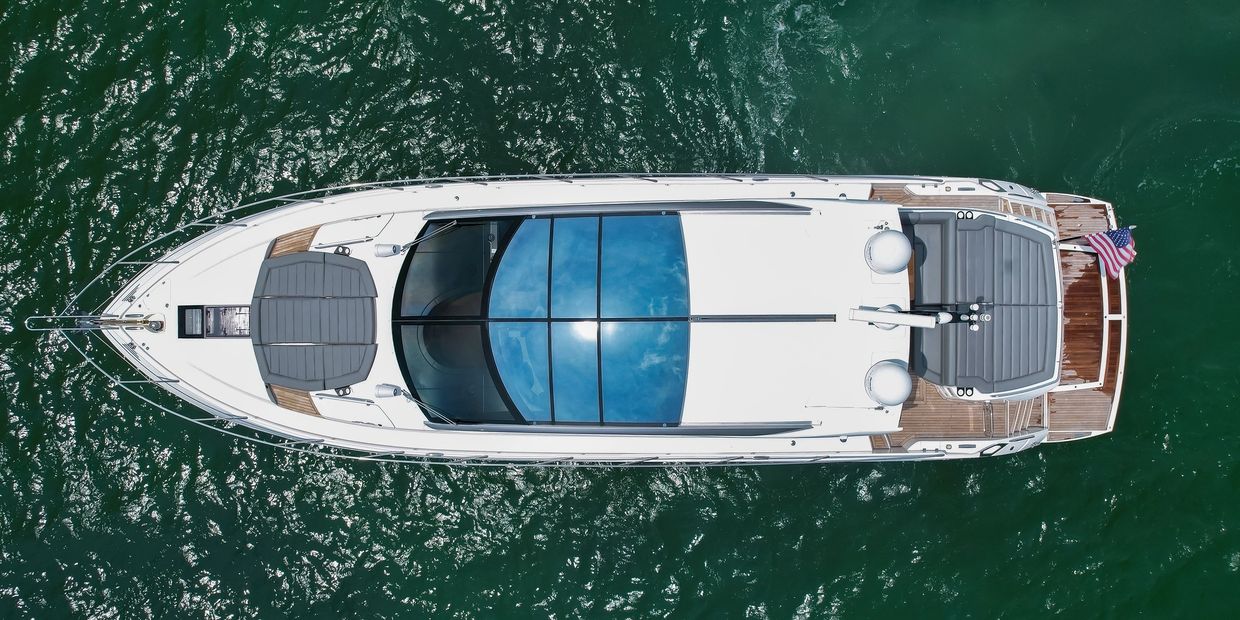 Aerial view of a white yacht on water.