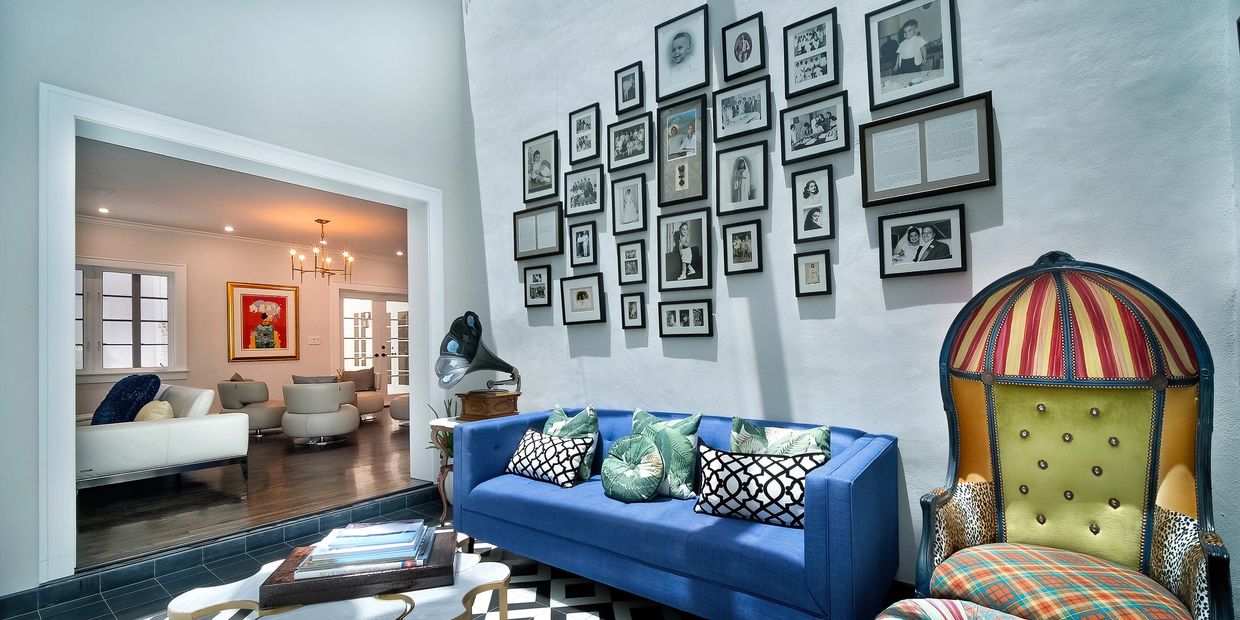 Designer living room with a gallery wall and blue velvet sofa in Miami