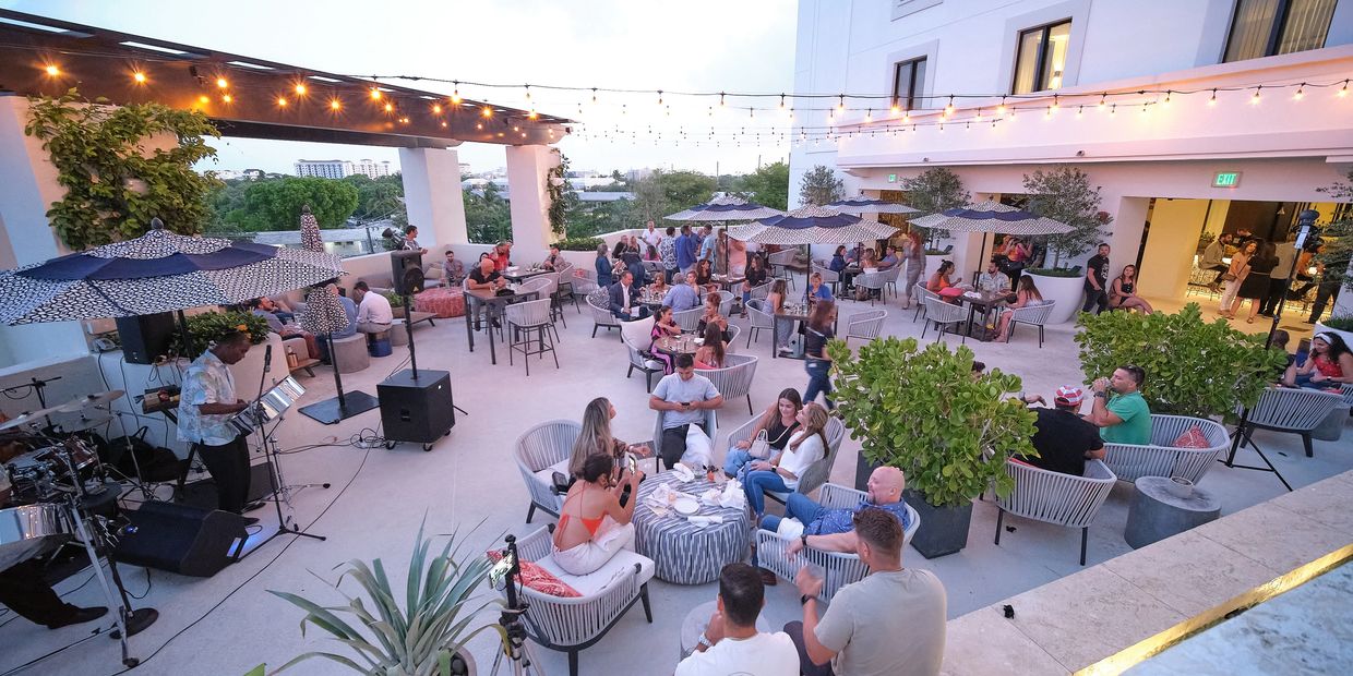 Guests at an outdoor evening reception under string lights at a Miami venue