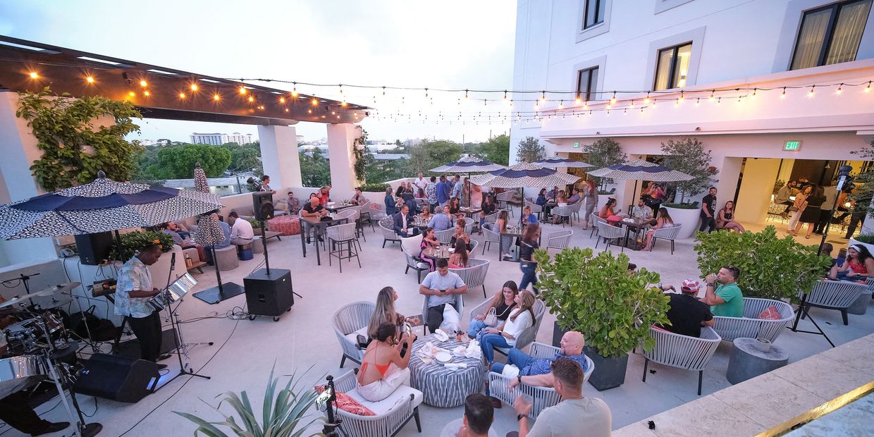 Guests at an outdoor evening reception under string lights at a Miami venue