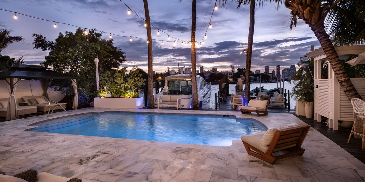 Twilight photograph of a Miami pool and terrace at dusk