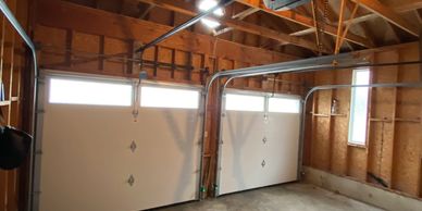 Empty two-car garage with wooden walls and ceiling.