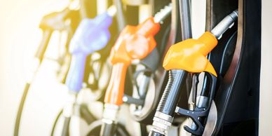 Colorful gas pump nozzles lined up at a fuel station.